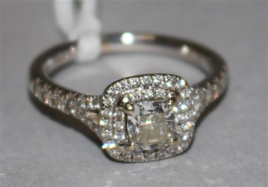 An 18ct gold and single stone diamond ring, surrounded by two concentric bands of brilliants, with diamond set shoulders, size L.